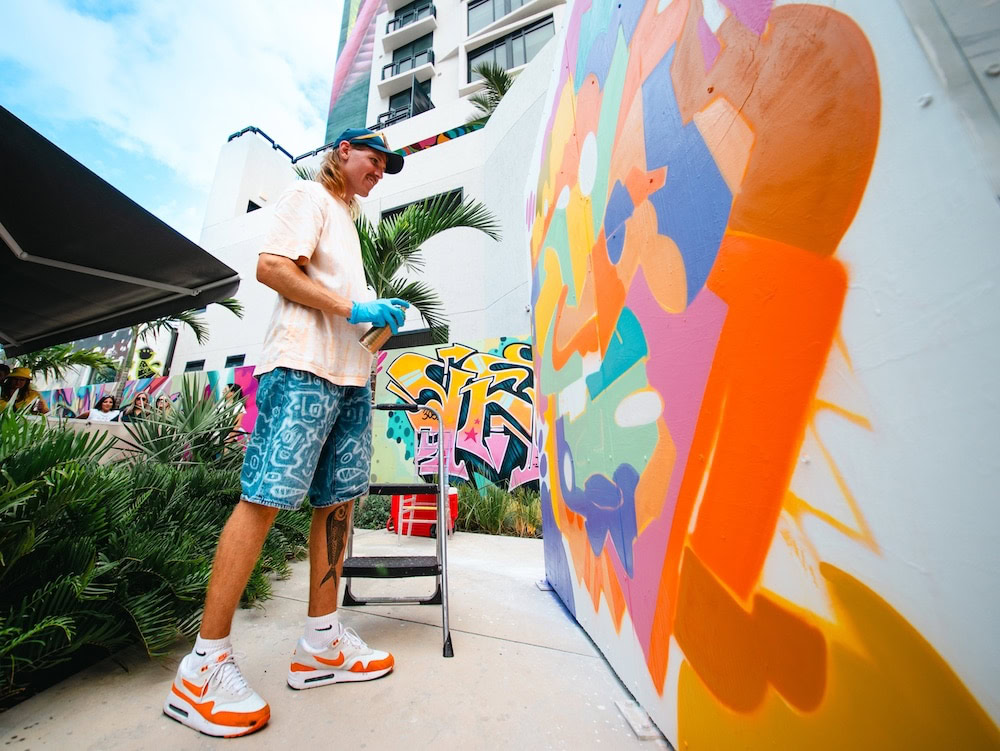 Street artist painting colorful mural at Wynwood Mural Festival during Miami Art Week 2025.”