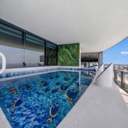 Daytime view of Porsche Design Tower Penthouse 4405 terrace with oceanfront pool, luxury finishes, and panoramic skyline backdrop.