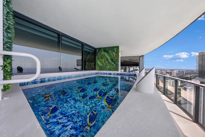 Daytime view of Porsche Design Tower Penthouse 4405 terrace with oceanfront pool, luxury finishes, and panoramic skyline backdrop.