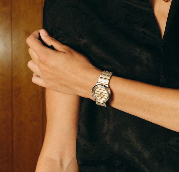 Versace FW25 silver timepiece worn with a black silk shirt, capturing understated elegance.