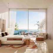 Primary bedroom at JEM Sky Villa with floor-to-ceiling windows, FENDI Casa furnishings and Biscayne Bay views.