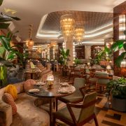 Interior of The Goodtime Hotel restaurant in South Beach with art deco design and chandeliers.