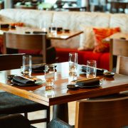 Elegant dining table setup inside Novikov Miami featuring modern wood furniture, glassware, and contemporary décor.