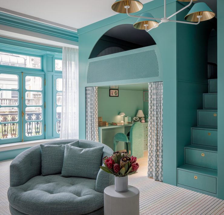 Playful kids room designed by Genevieve Lake featuring teal walls, built-in staircase with storage, and cozy reading nook.