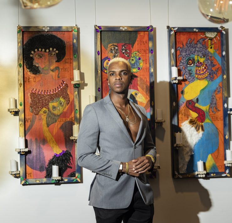 Artist posing with contemporary art pieces at The Betsy South Beach gallery exhibition for Miami Art Week.
