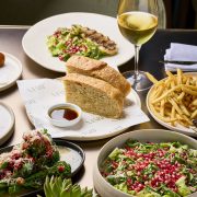 Mediterranean lunch set with salad, bread, and wine at ADRIFT Mare Miami.
