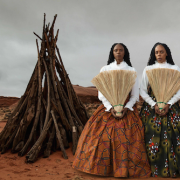 Portrait-style artistic photograph of two women in traditional-inspired attire with fans, exhibited for Miami Art Week.
