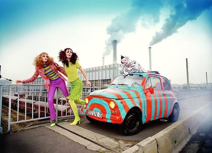 Editorial-style art photograph of models and a painted vintage car displayed during Miami Art Week exhibitions.