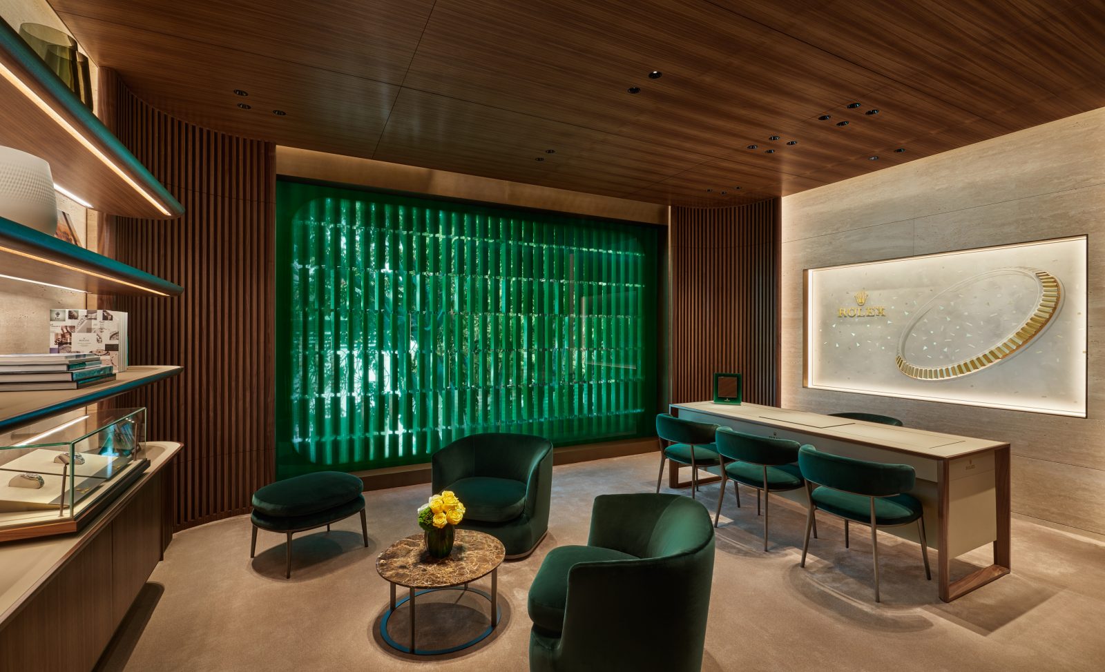 Private consultation lounge with emerald chairs, wood ceiling, and refined interior finishes in luxury showroom
