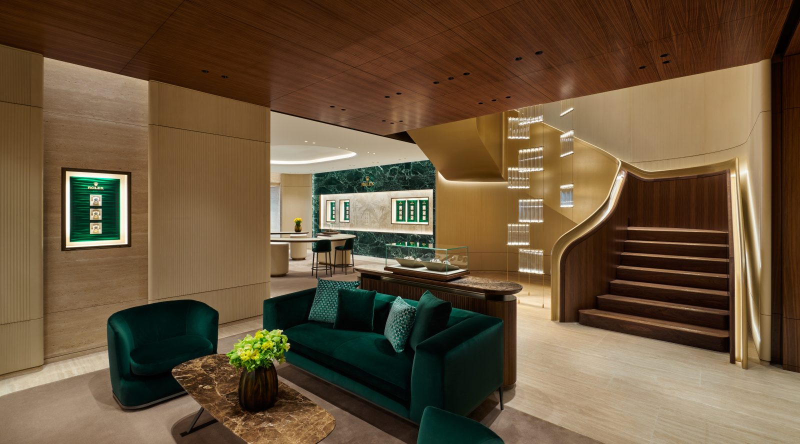 Luxury boutique lounge with emerald seating and sculptural staircase leading to second level