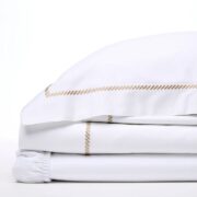 Trousseau Domino Collection white bedding with gold embroidered trim and crisp sheet detailing