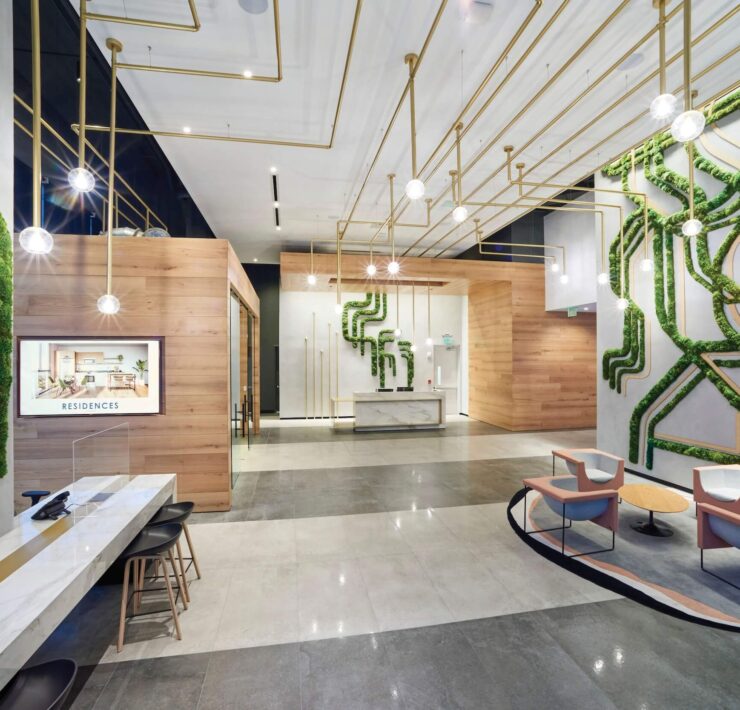 Luxury lobby with moss wall installations, brass lighting, wood accents & modern seating