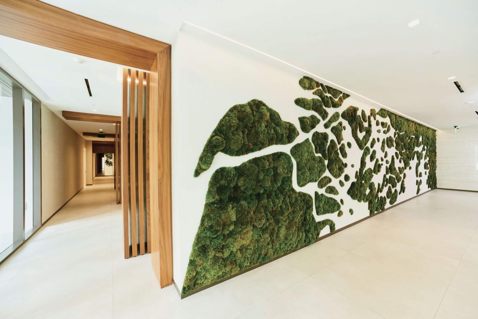 Modern hallway featuring a large preserved moss wall installation and warm wood details