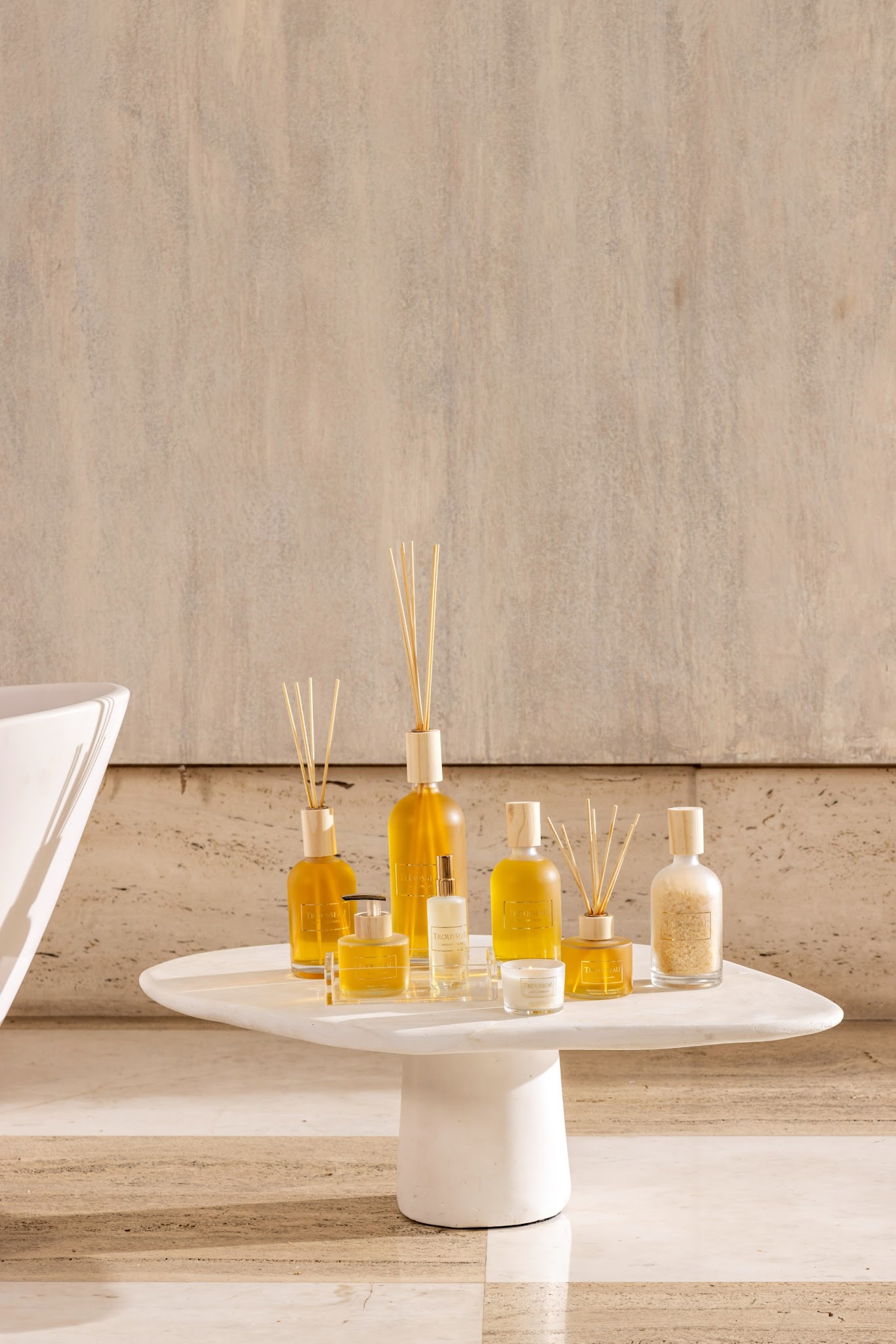 Trousseau Printemps Collection home fragrance with diffusers, candles, and room sprays on a sculptural white table