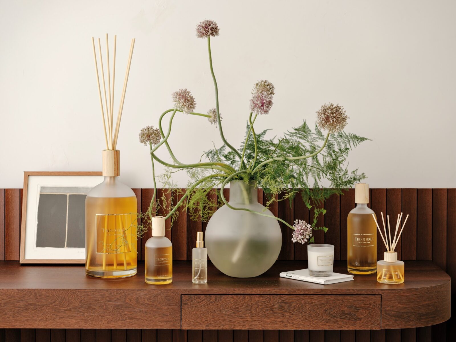 Trousseau Printemps Collection home fragrance with diffusers, candles, and floral styling on a wood console