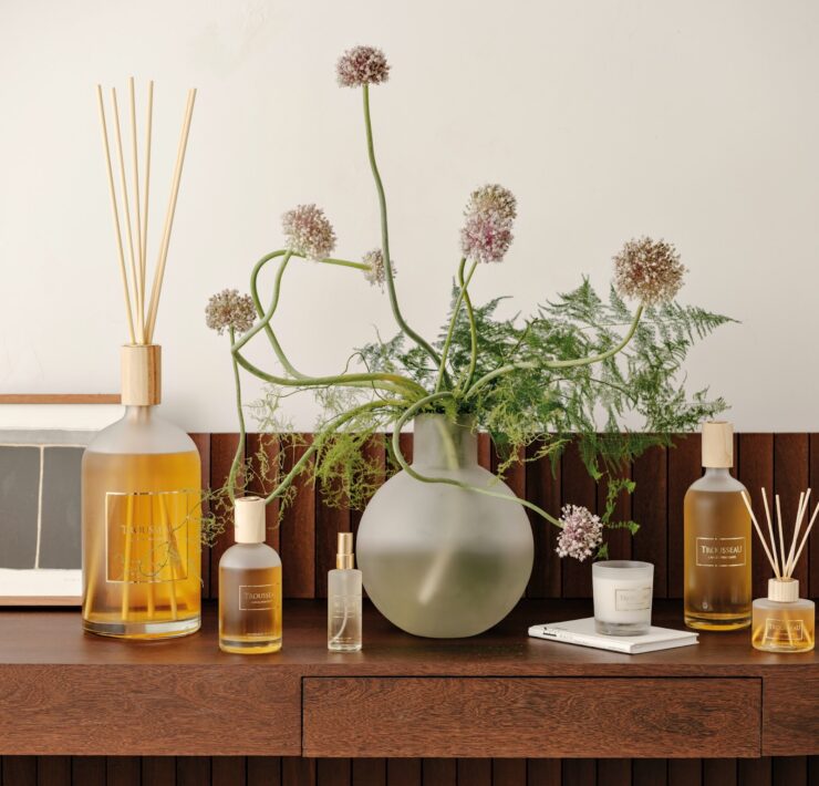 Trousseau Printemps Collection home fragrance with diffusers, candles, and floral styling on a wood console