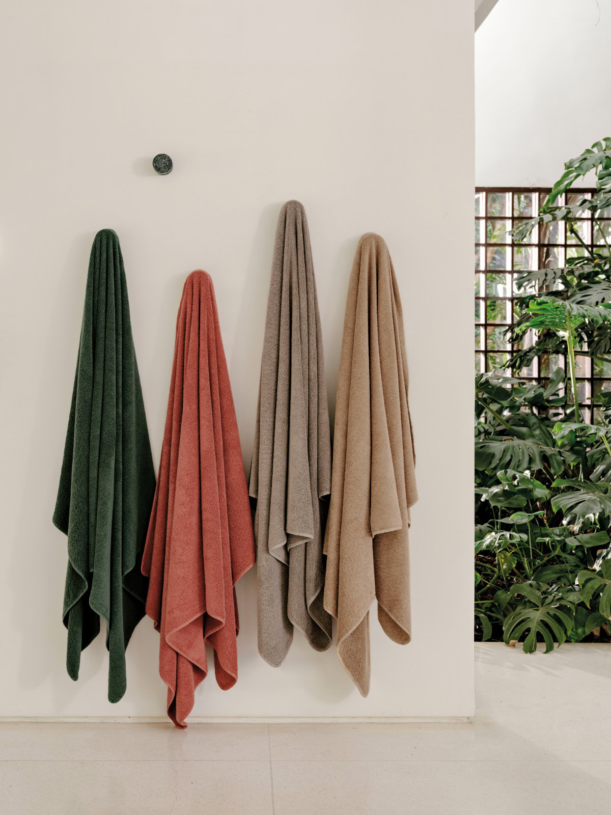 Trousseau Twill Towel collection with colorful bath towels in green, coral, beige, and taupe tones