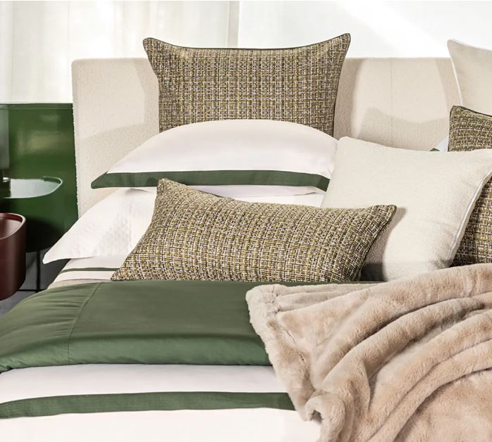 Trousseau Verdeluce Collection bedding with green accents, textured pillows, and layered white sheets