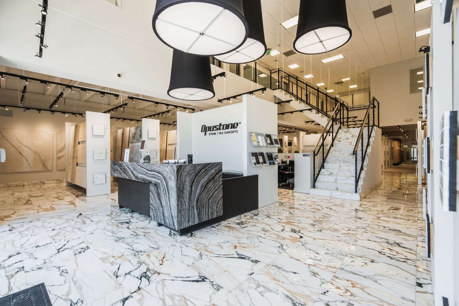 Opustone showroom with marble floors, large stone slab displays, modern tile concepts, and luxury surface materials