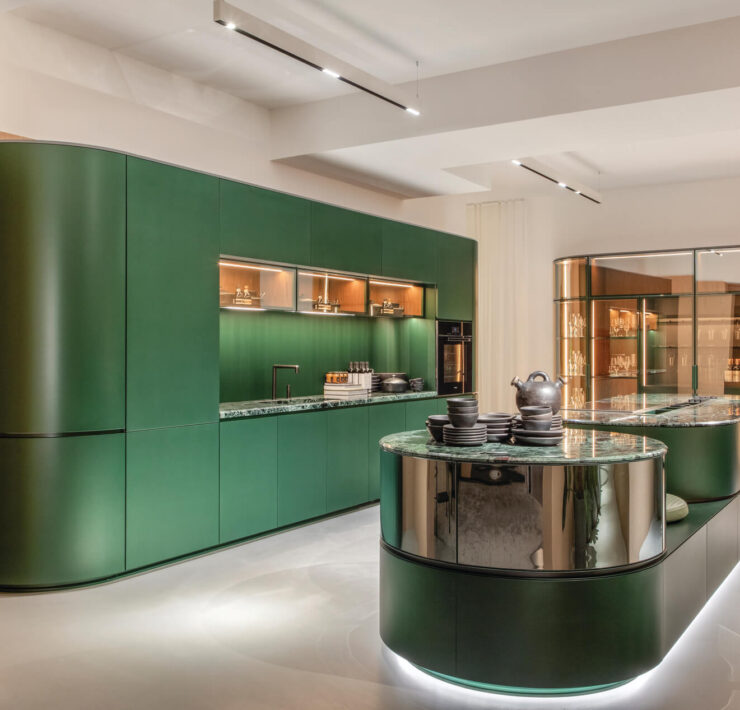 Florense Arco by Pininfarina luxury green kitchen with curved cabinetry, marble surfaces, glass display storage, and integrated lighting.