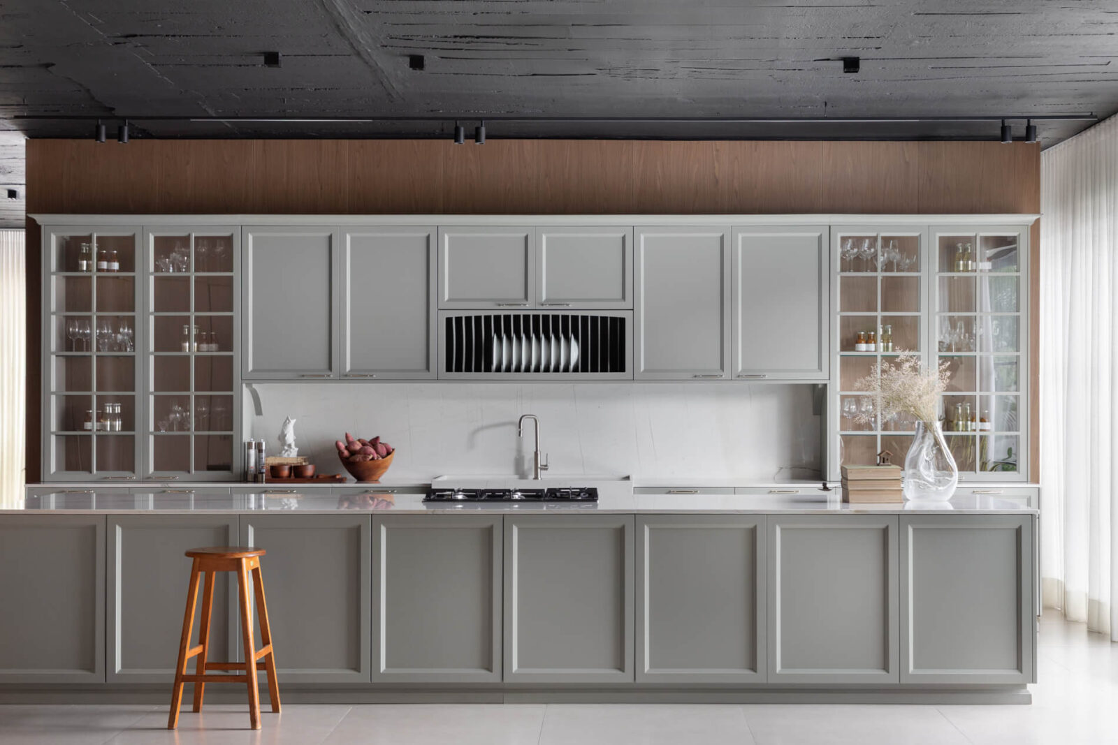 Florense Bistrot kitchen with gray paneled cabinetry, glass-front cabinets, white countertops, and warm wood detailing.