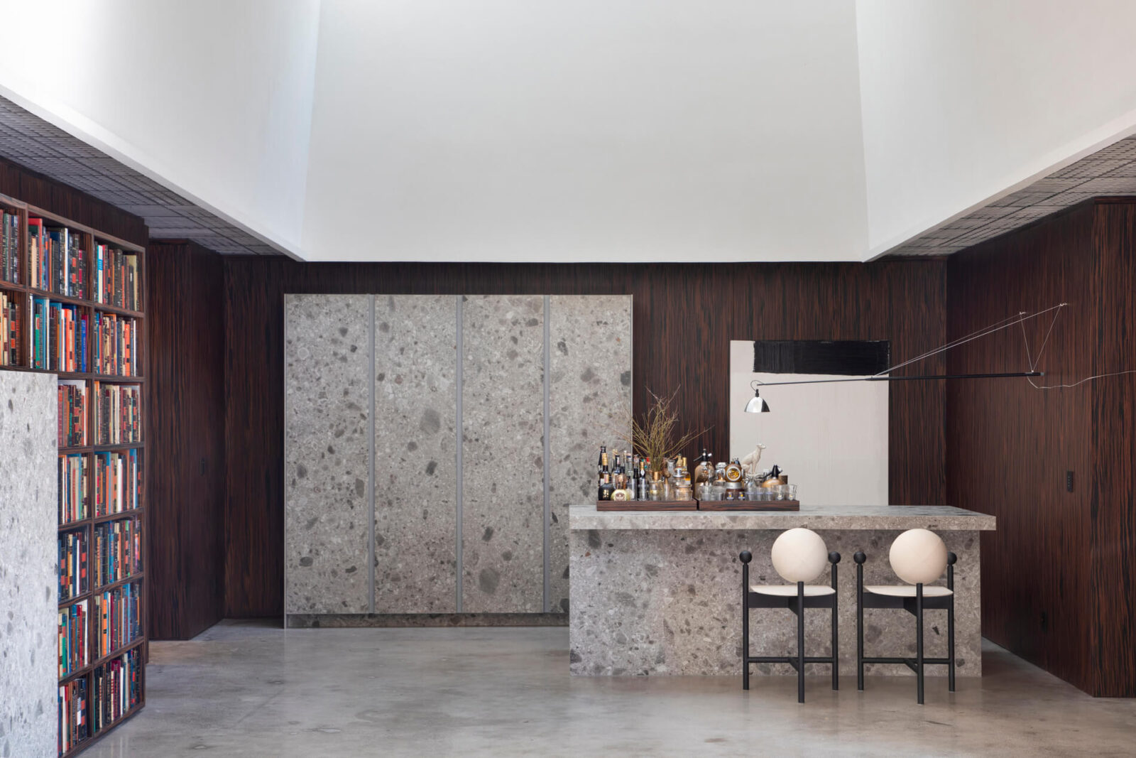 Florense Countertop Sliding System and Vetrata cabinetry with stone bar, dark wood walls, glass shelving, and concealed storage.