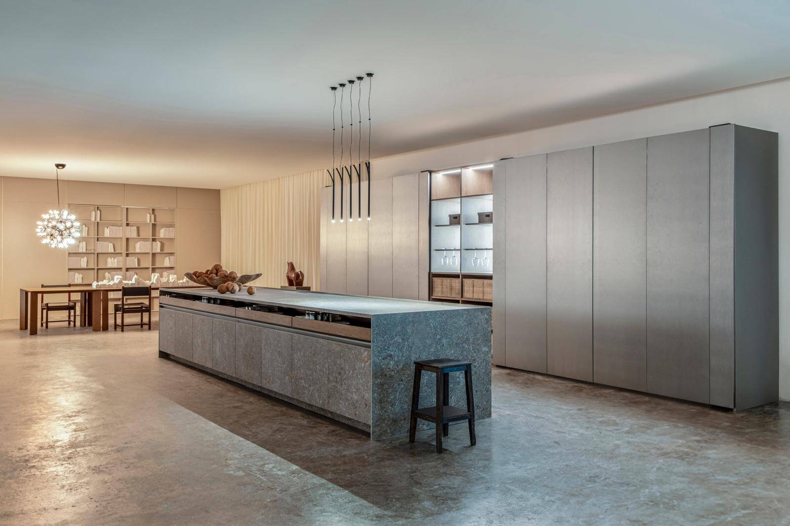Florense Eclipse III kitchen with concealed panel system, stone island, gray cabinetry, and integrated storage wall.