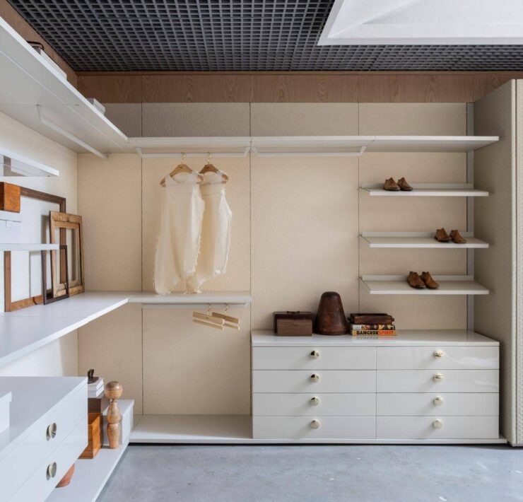 Florense FloWall closet system with open shelving, white drawers, hanging storage, brass hardware, and textured wardrobe doors.