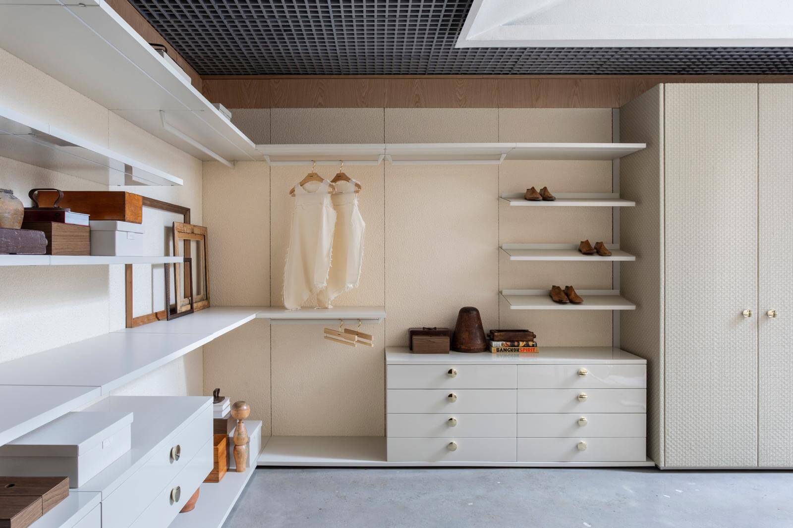 Florense FloWall closet system with open shelving, white drawers, hanging storage, brass hardware, and textured wardrobe doors.