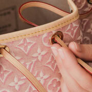 inserting the loop through the eyelets of the noe monogram embleme