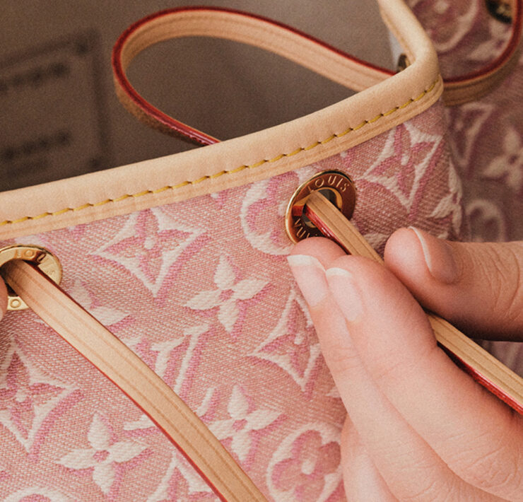 inserting the loop through the eyelets of the noe monogram embleme