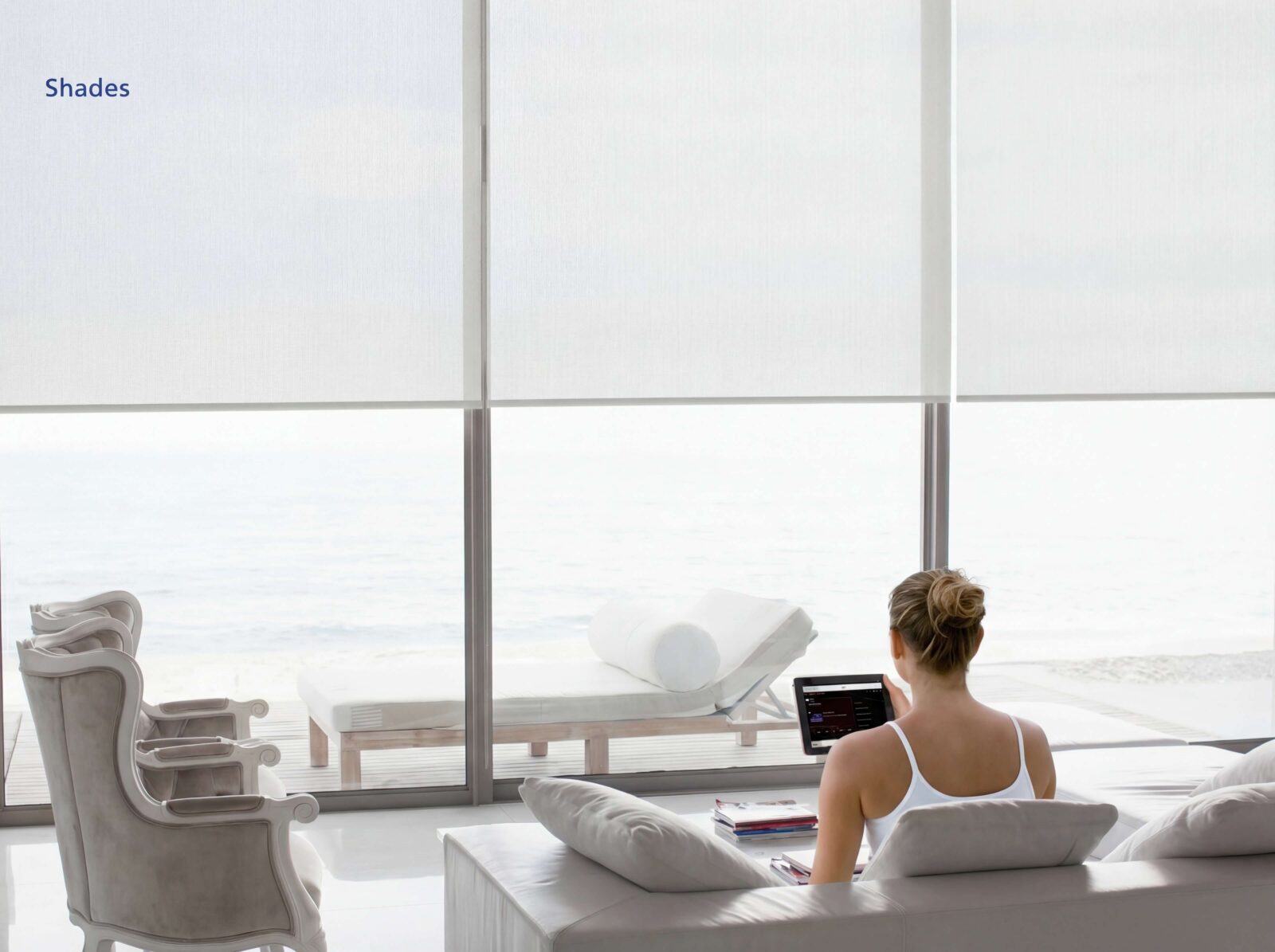 Luxury smart shades in a bright oceanfront home controlled by tablet with automated window treatment integration by Sound & Vision Technology