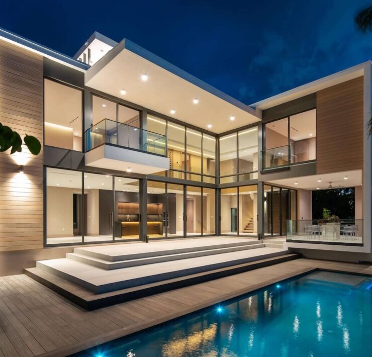 Trazzo modern waterfront residence lighting with illuminated exterior, pool lighting, glass walls, and luxury architectural lighting design.