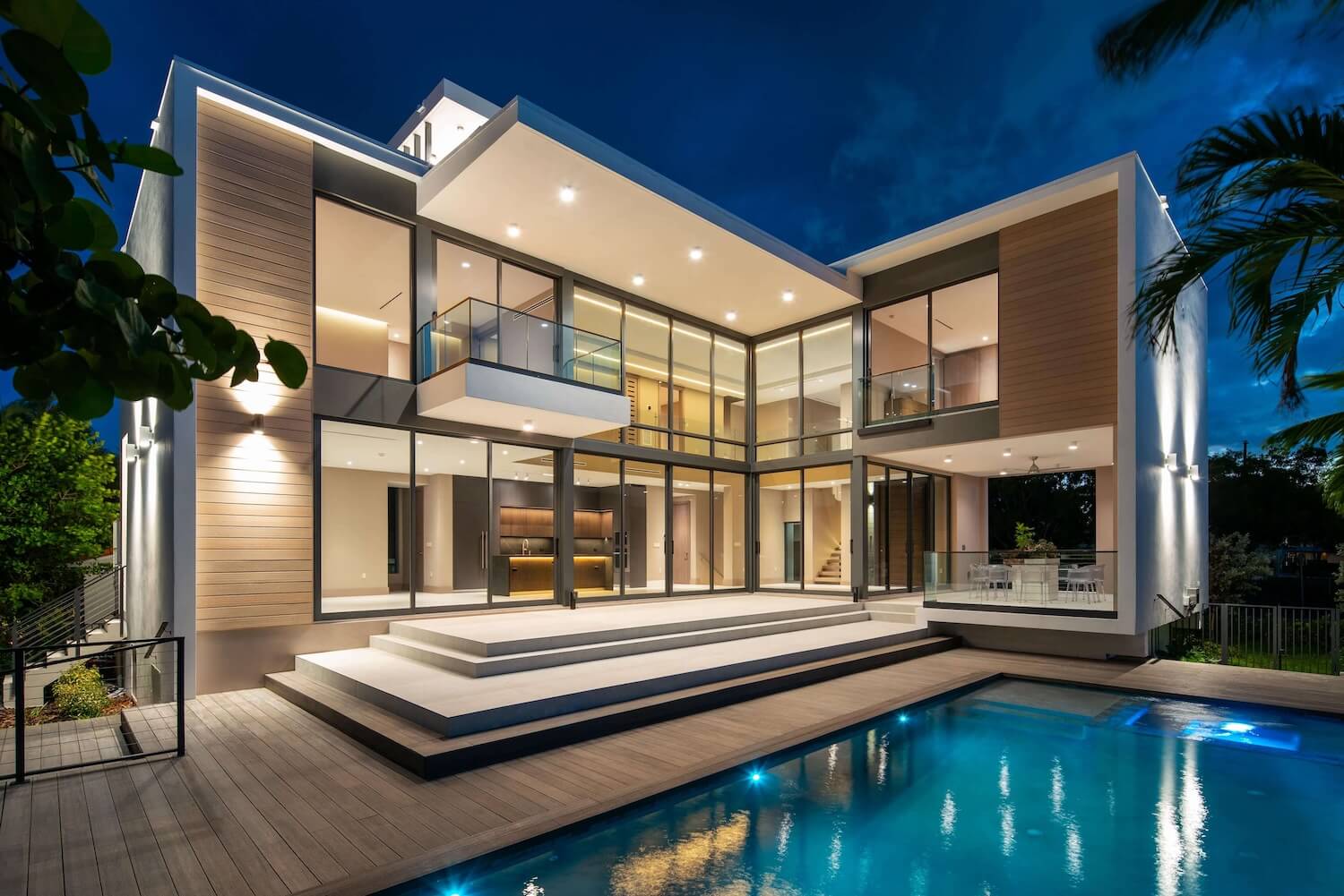 Trazzo modern waterfront residence lighting with illuminated exterior, pool lighting, glass walls, and luxury architectural lighting design.
