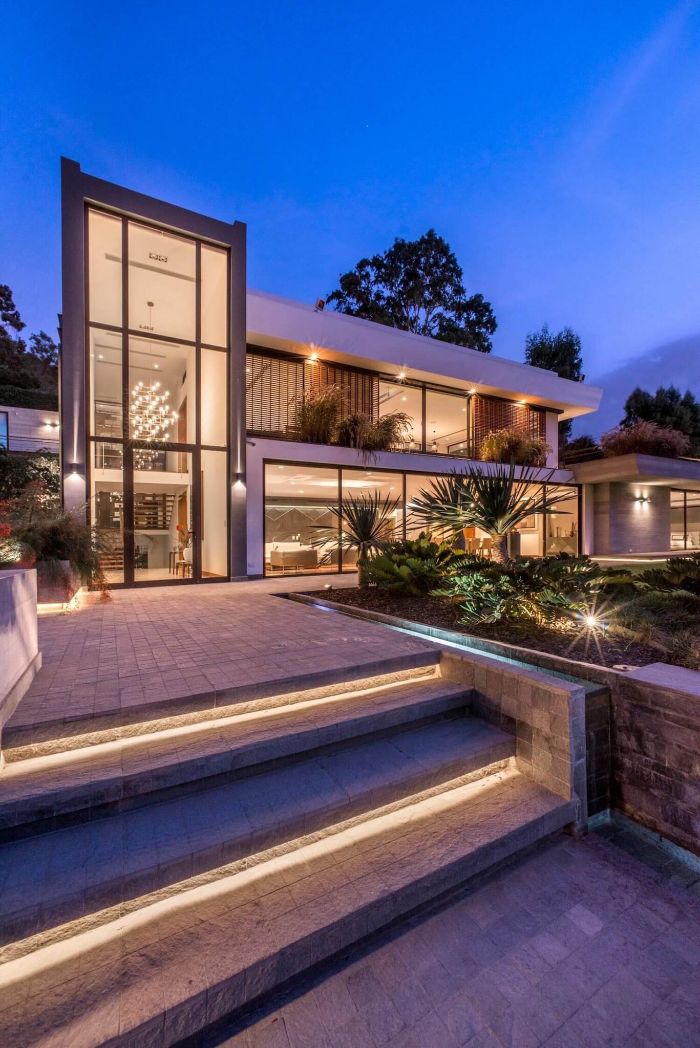 Trazzo contemporary exterior landscape lighting with illuminated steps, facade lighting, garden accents, and modern residential architecture.