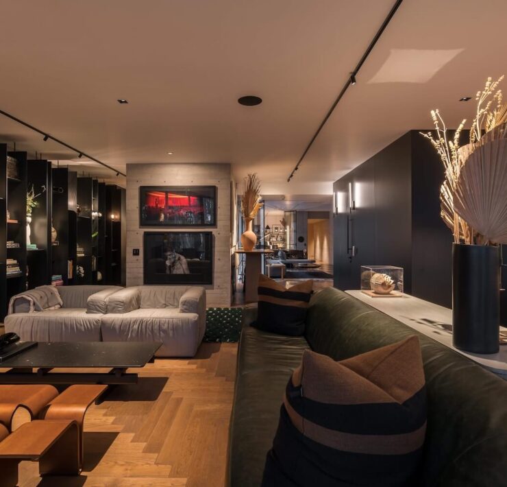 Trazzo moody residential interior lighting with track lighting, wall sconces, shelf lighting, and layered ambient illumination.