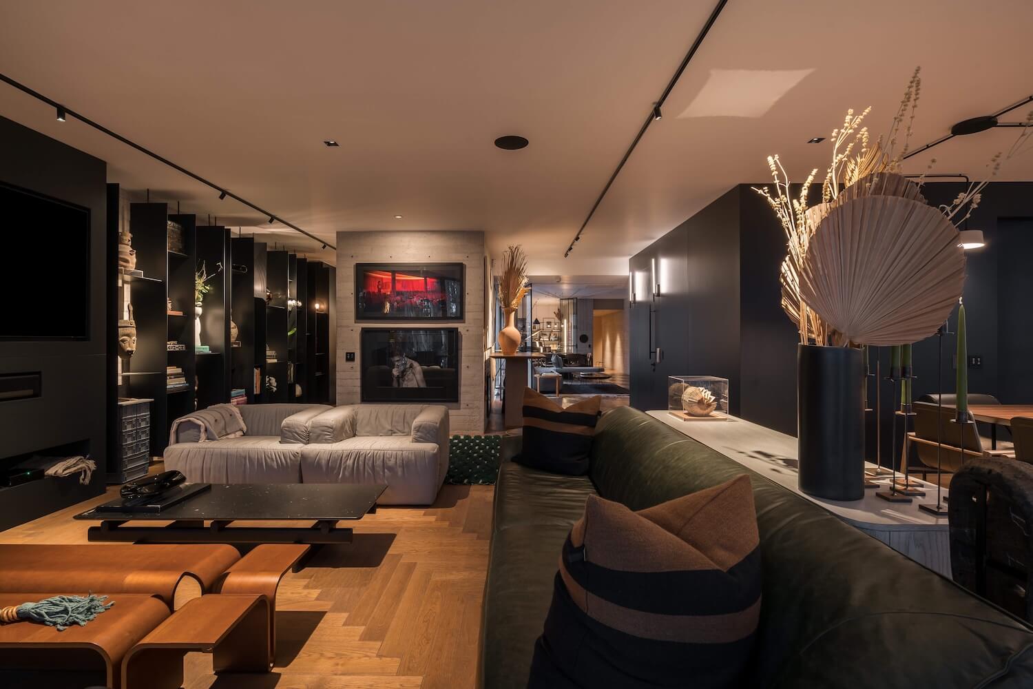 Trazzo moody residential interior lighting with track lighting, wall sconces, shelf lighting, and layered ambient illumination.