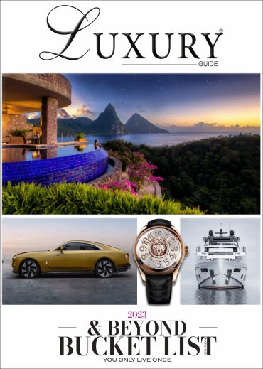 2023 Bucket List Edition Luxury Guide 2023 “& Beyond Bucket List” cover featuring a tropical resort overlooking mountain peaks, a luxury car, watch, and yacht.