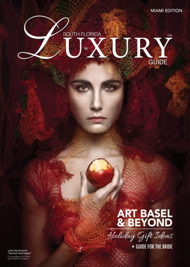 Luxury Guide Cover Winter 2017-2018 South Florida Luxury Guide Miami cover featuring a woman in red textured fashion holding a red apple against a dark, dramatic backdrop.